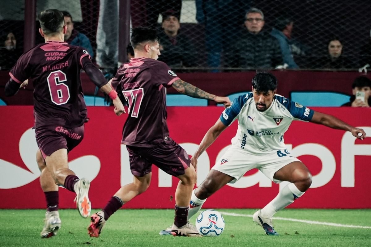 Luis Segovia, de Liga de Quito, ante jugadores de Lanús. Foto: LDU