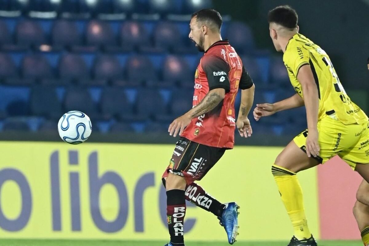 Lucas Mancinelli, de Deportivo Cuenca, ante un jugador de Recoleta, en Paraguay. Foto: Dep. Cuenca