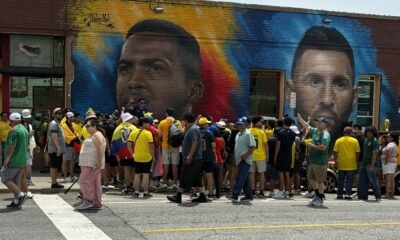 Los ecuatorianos se fotoma fotografías en el mural de Willian Pacho, en Kansas.