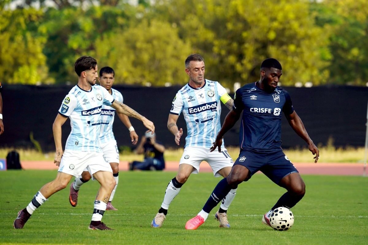 Damián Díaz, de Guayaquil City, ante jugadores de Universidad Católica. Foto: API
