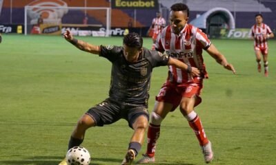 Bagner Delgado (der.), de Técnico Universitario, marca a Marcos Andrés López, de Deportivo Cuenca. Foto: API