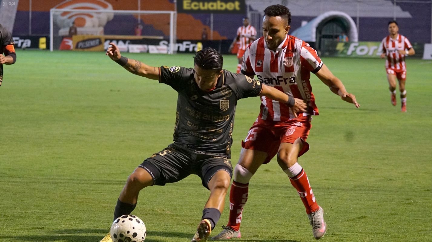 Bagner Delgado (der.), de Técnico Universitario, marca a Marcos Andrés López, de Deportivo Cuenca. Foto: API